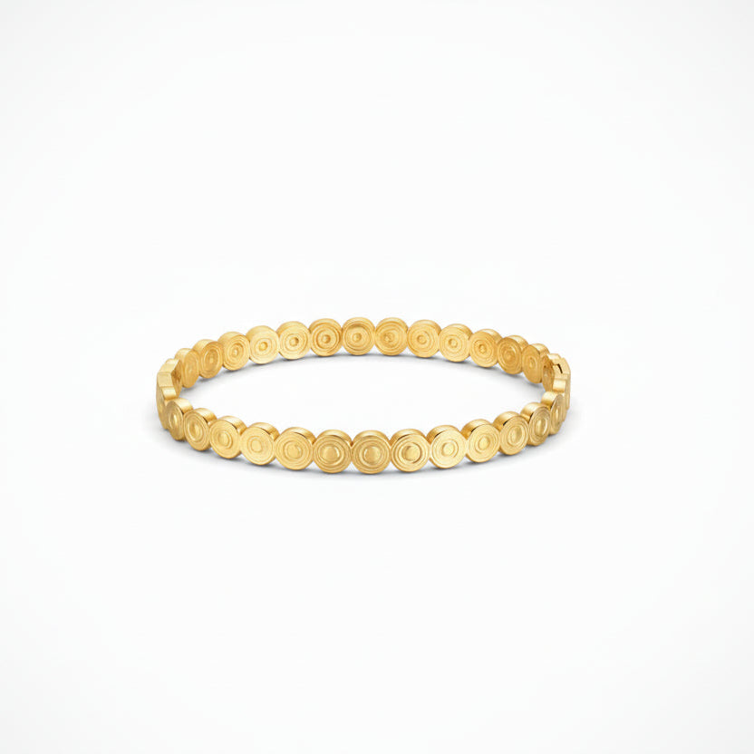 Gold bracelet with circular pattern on a white background
