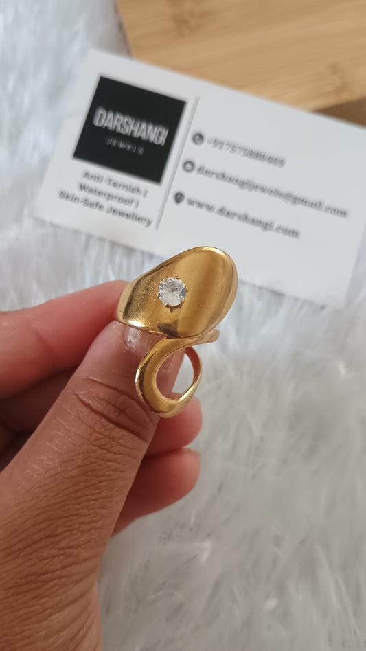 Gold ring with a diamond held by a hand on a blurred background