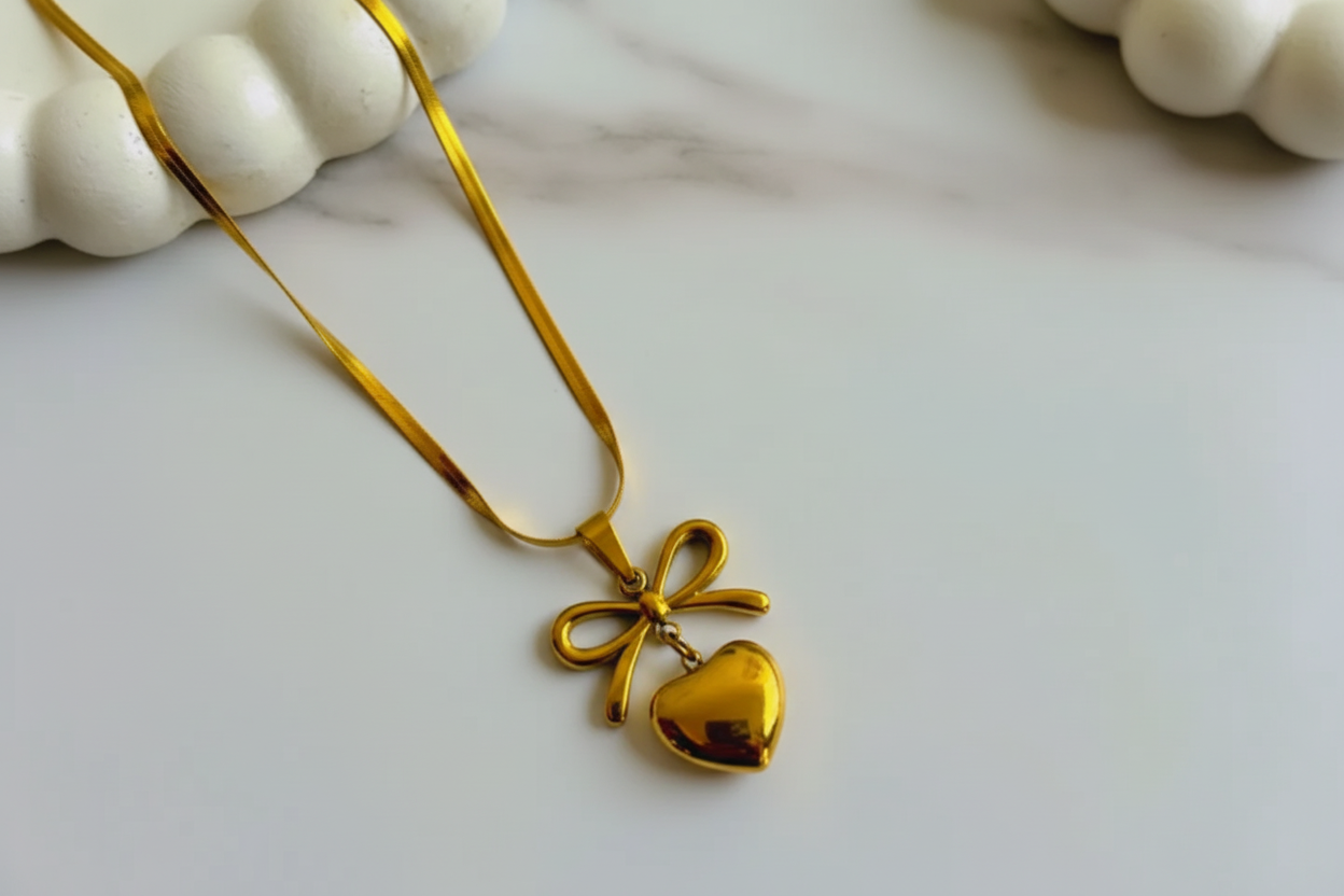 Gold bow heart necklace on a white background with 'Lavender' brand name.