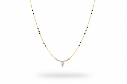 Gold necklace with a heart-shaped pendant on a neutral background