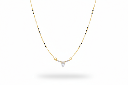 Gold necklace with a heart-shaped pendant on a neutral background