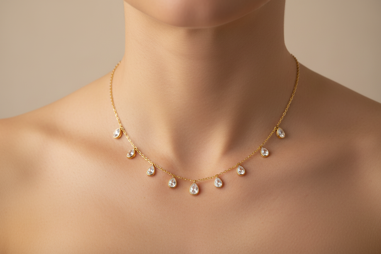 Gold necklace with teardrop-shaped diamonds on a white background